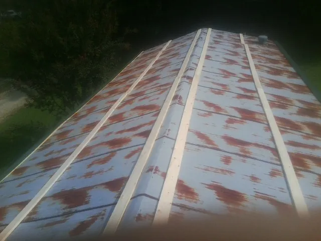 Rusted metal roof panels with new wood purlins before replacement — Storm Damage Roof Repair in Norton by Roofing Brothers