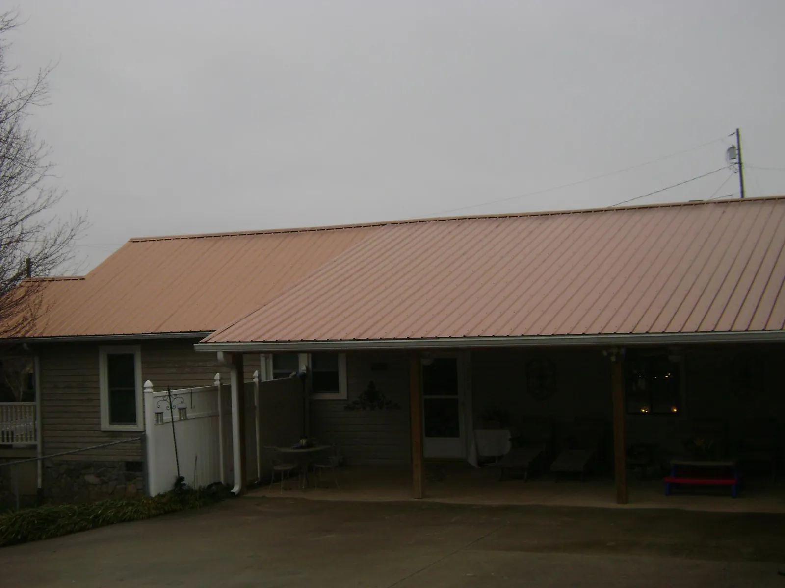 Copper toned metal roof over a wide covered patio in Norton
